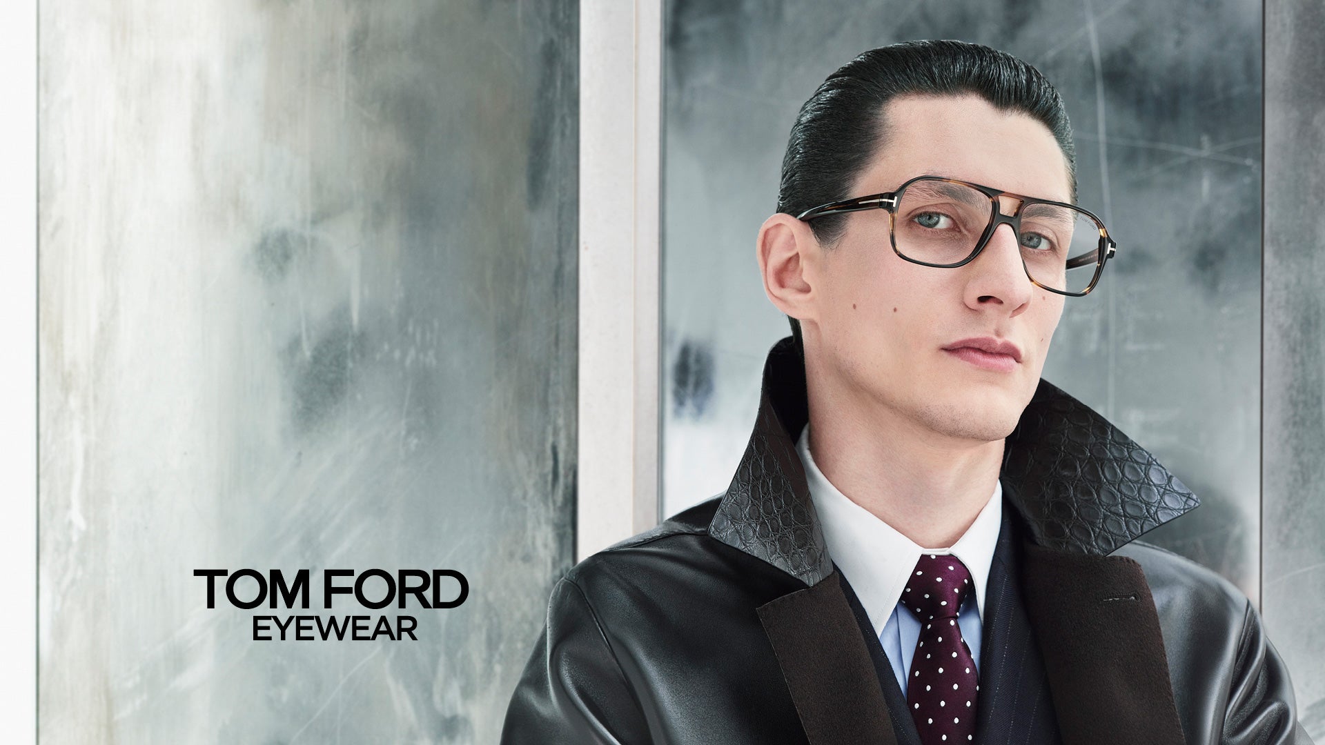 Man wearing glasses and a suit with 'Tom Ford Eyewear' branding.